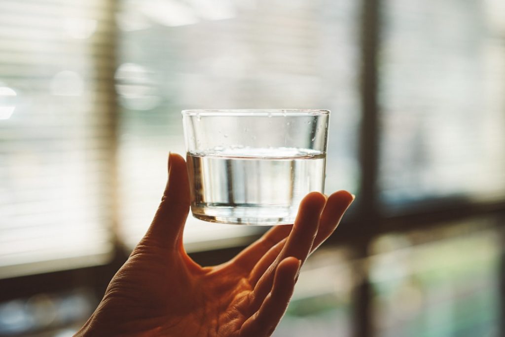 person-holding-clear-glass-cup-with-half-filled-water-12kb5ynfxso